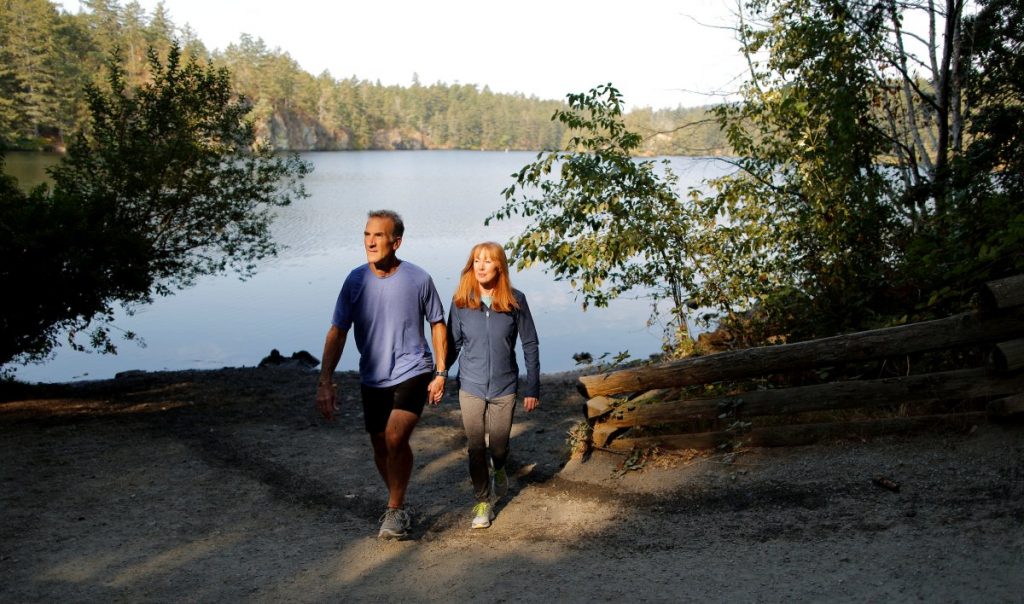 Jason Dorland and Robyn Meagher walking together beside a lake